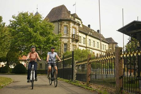 Radfahrer vor dem Wasserschloss Heerse in Neuenheerse.